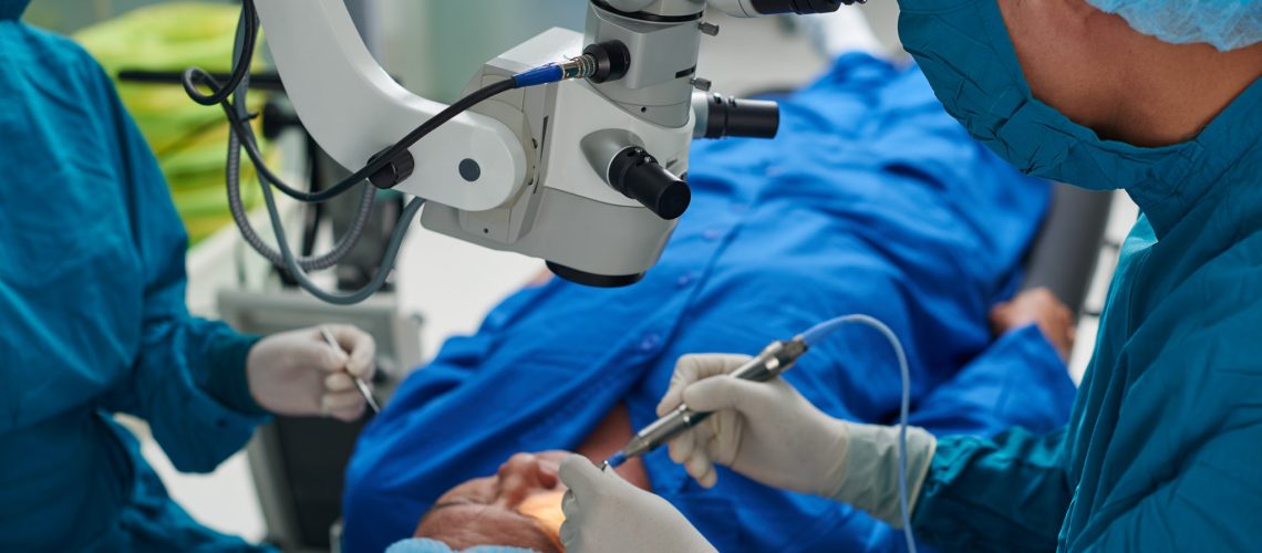 Doctor performing eye surgery in modern clinic